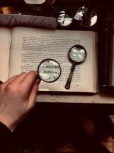 Reading book using magnifying glass