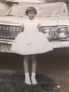 Young girl in front of car